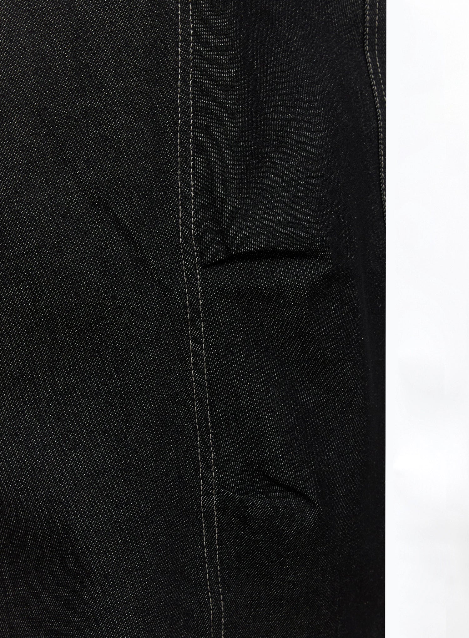 Ayra Graphic Baggy Jeans IO516 in Black, macro close-up of side seam and slit pocket detail, heavy cotton denim texture with white contrast stitching visible.
