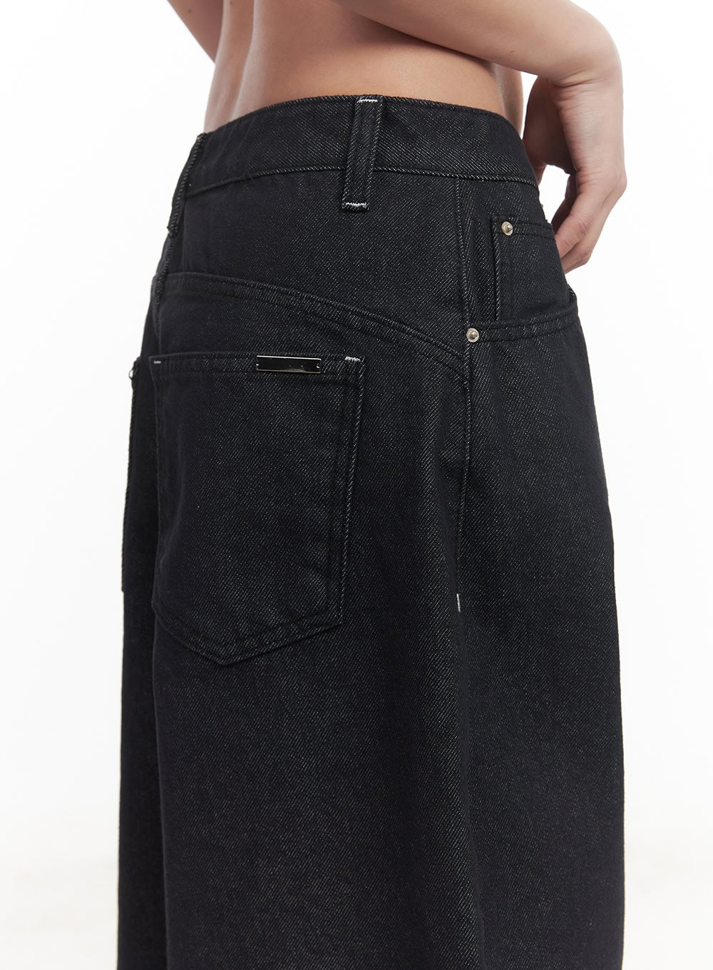Julianna Baggy Jeans CM505 in black denim, back waist close-up on model, showing rear patch pockets, silver hardware rivets, and structured belt loop detail on cotton denim.