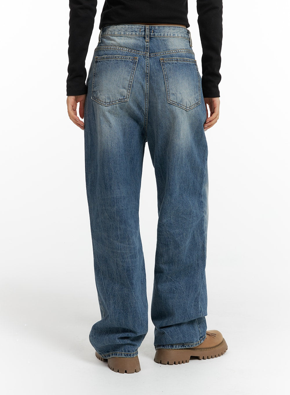 Wide Washed Denim Jeans CF419 in blue, back view on model, wide-leg washed denim with contrast stitching on back pockets and vintage fading, tan lug-sole boots.