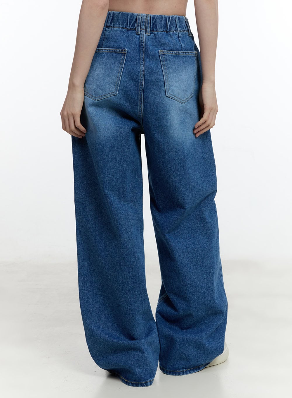 Eugene Adjustable Cinched-Back Wide-Leg Jeans CM521 in dark blue, back close-up on model, showing elasticated cinched waistband, patch back pockets, and wide-leg washed denim silhouette.