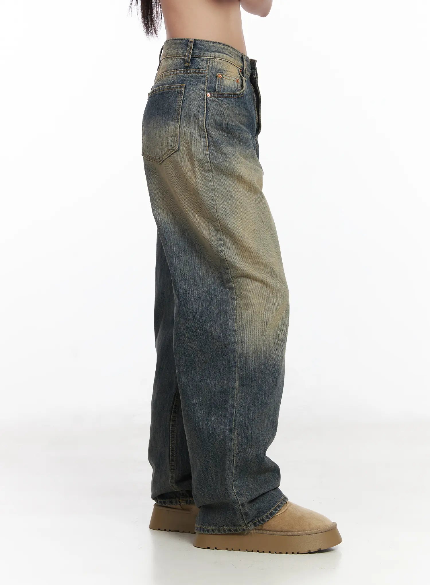 Wide Washed Jeans CS06 in vintage blue, close-up side view on model, wide-leg washed denim highlighting sandy yellow fade along side seam, back pocket detail, cotton fabric texture visible.