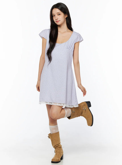 Romantic Floral Lace Trim Mini Dress CU522 in light purple, full-body front view on model in playful pose, floral print A-line mini, lace hem, paired with tan buckle boots and lace ankle socks.