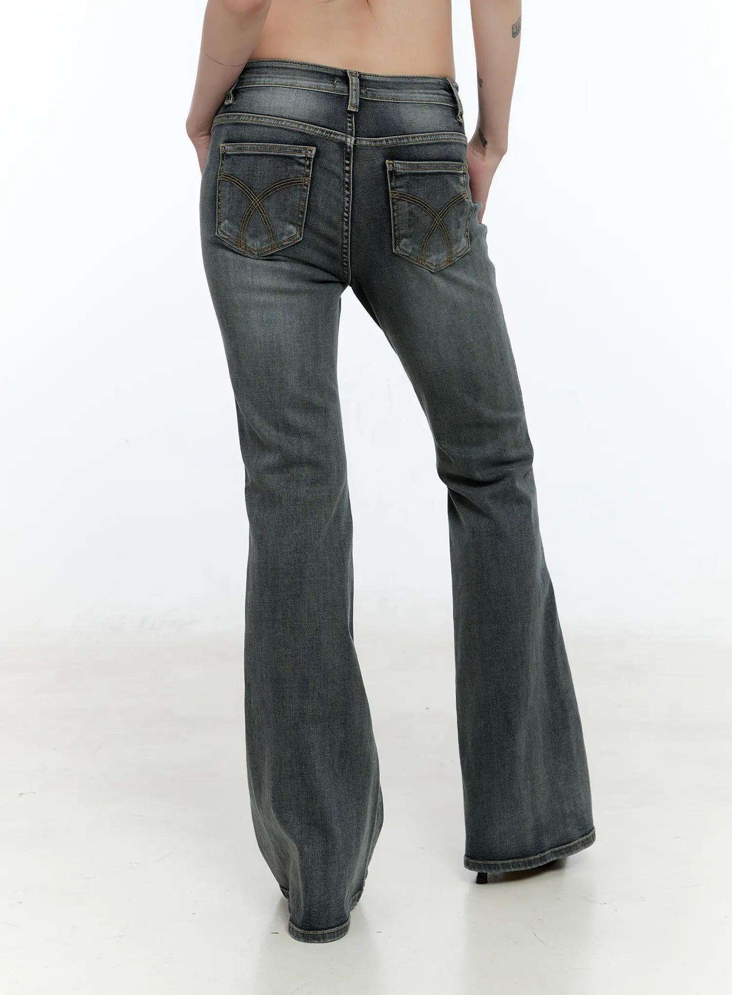 Judith Washed Bootcut Jeans CN517 in blue, back three-quarter crop on model, washed grey denim with arc-embroidered back pockets and wide bootcut hem silhouette.