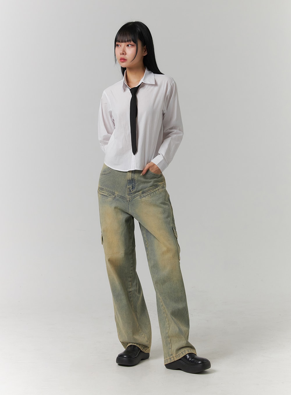Cargo Denim Straight Leg Jeans CJ422 in blue, full-body side-angled view on model looking away, wide-fit washed denim with cargo pockets, paired with white cropped shirt and black tie.