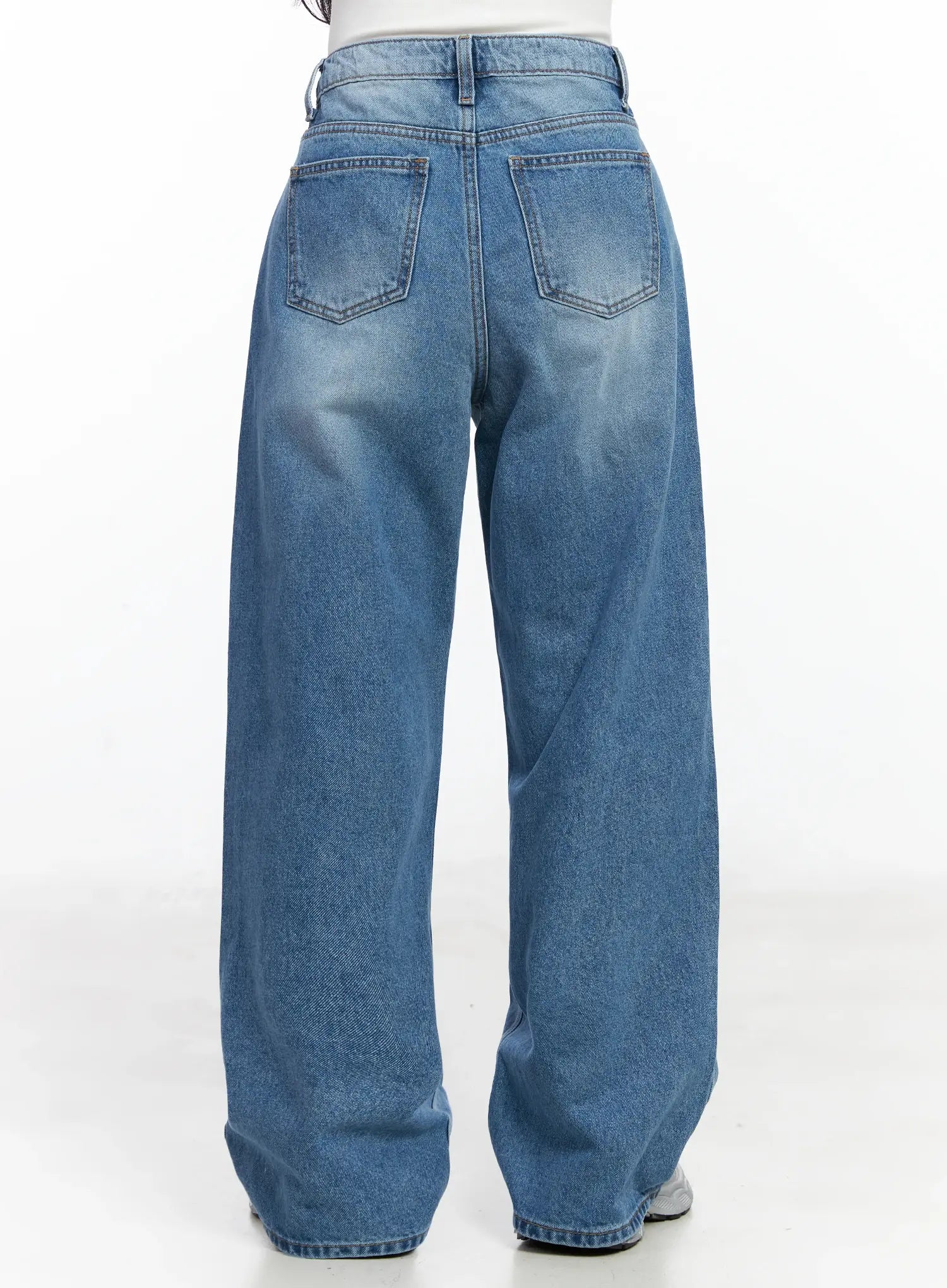 Iliana Wide Leg Jeans IJ529 in blue, back full-length view on model, wide-leg washed denim with dual back pockets and relaxed long fit, silver sneakers.