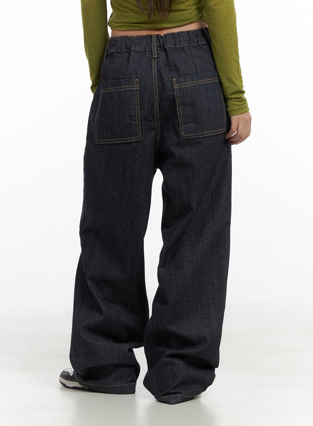 Lola Pintuck Baggy Jeans CO402 in dark blue, back detail close-up on model, showing large patch pockets with contrast stitching and elasticated waist, wide baggy denim leg.