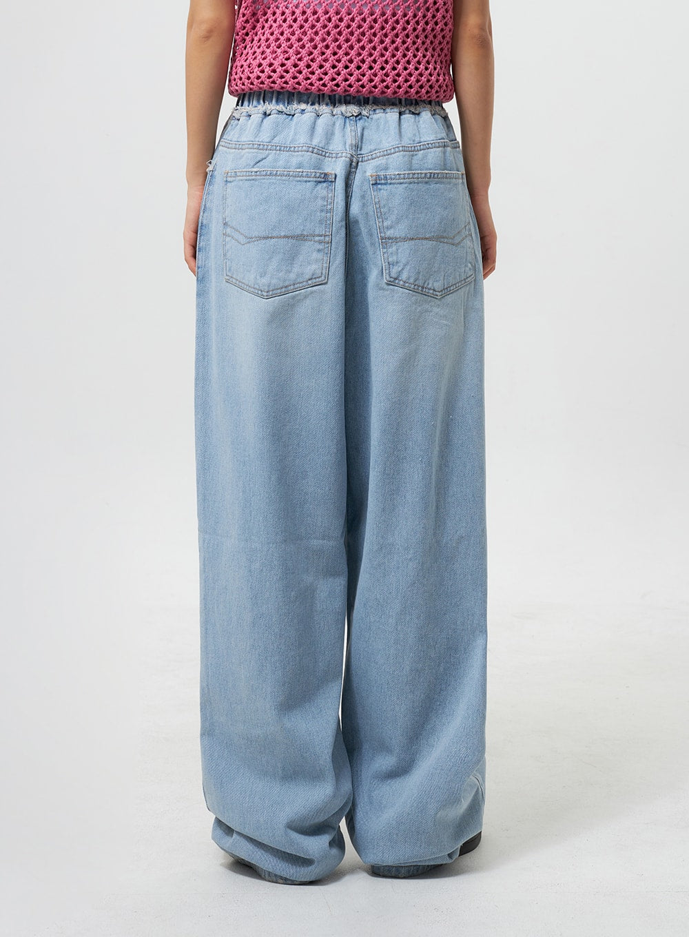 Oversized Ripped Jeans CY324 in light blue, back view on model, showing clean double back pockets, elastic banded waistband, and wide floor-length denim leg silhouette.