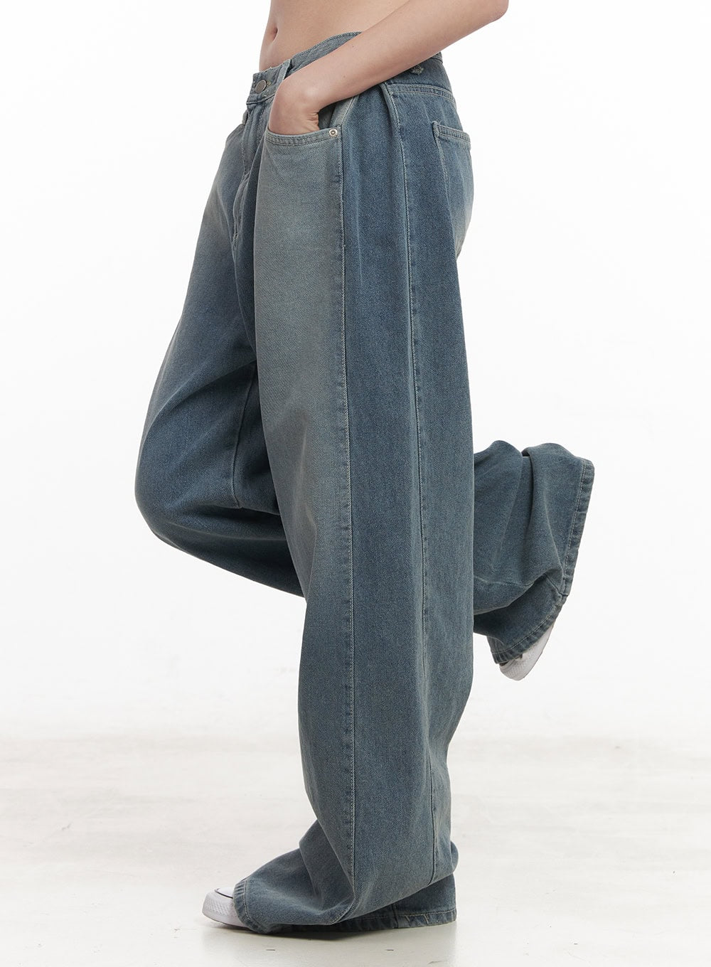 Amber Pintuck Wide-Leg Jeans CM511 in blue, side full-length shot on model with leg raised, pintuck crease visible, voluminous wide-leg washed denim silhouette.