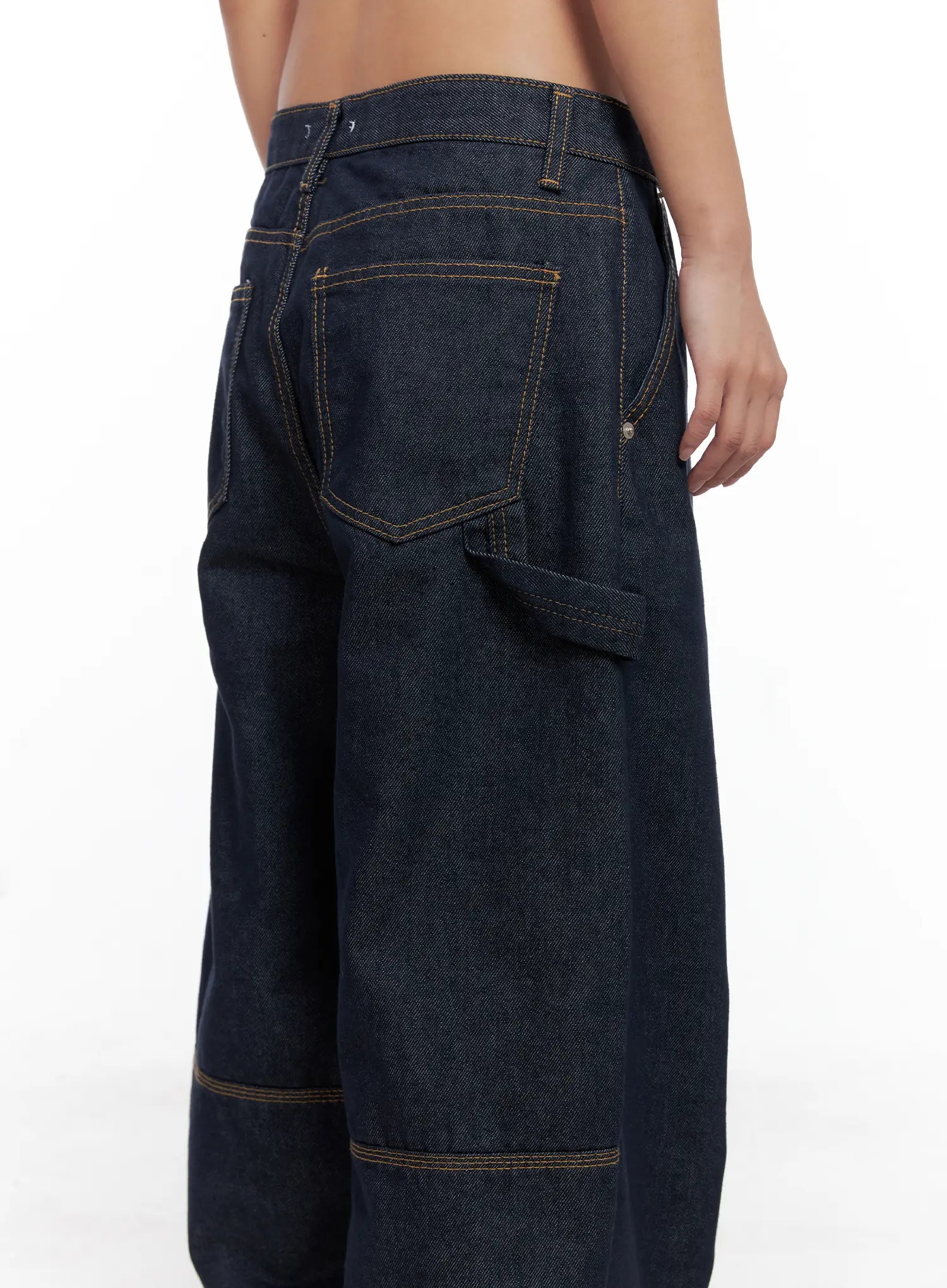 Relaxed Fit Dark Denim Jeans CS522 in dark blue, back close-up on model, back patch pockets with contrast topstitching, carpenter hammer loop and panelled knee seam detail visible.