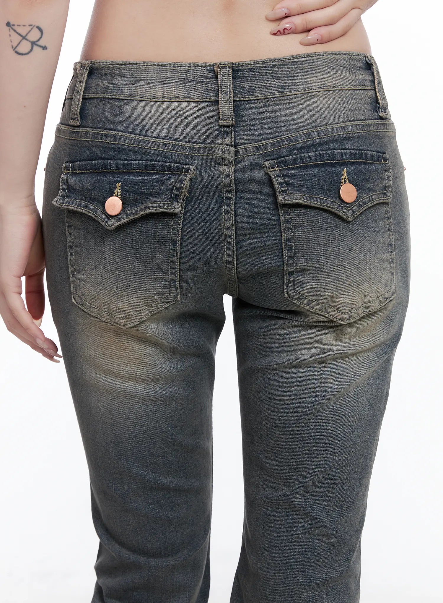 Sumin Low-Rise Flare Hip Pad Jeans CG529 in gray, back close-up on model, showing dual flap pockets with rose gold button rivets and vintage washed denim texture.