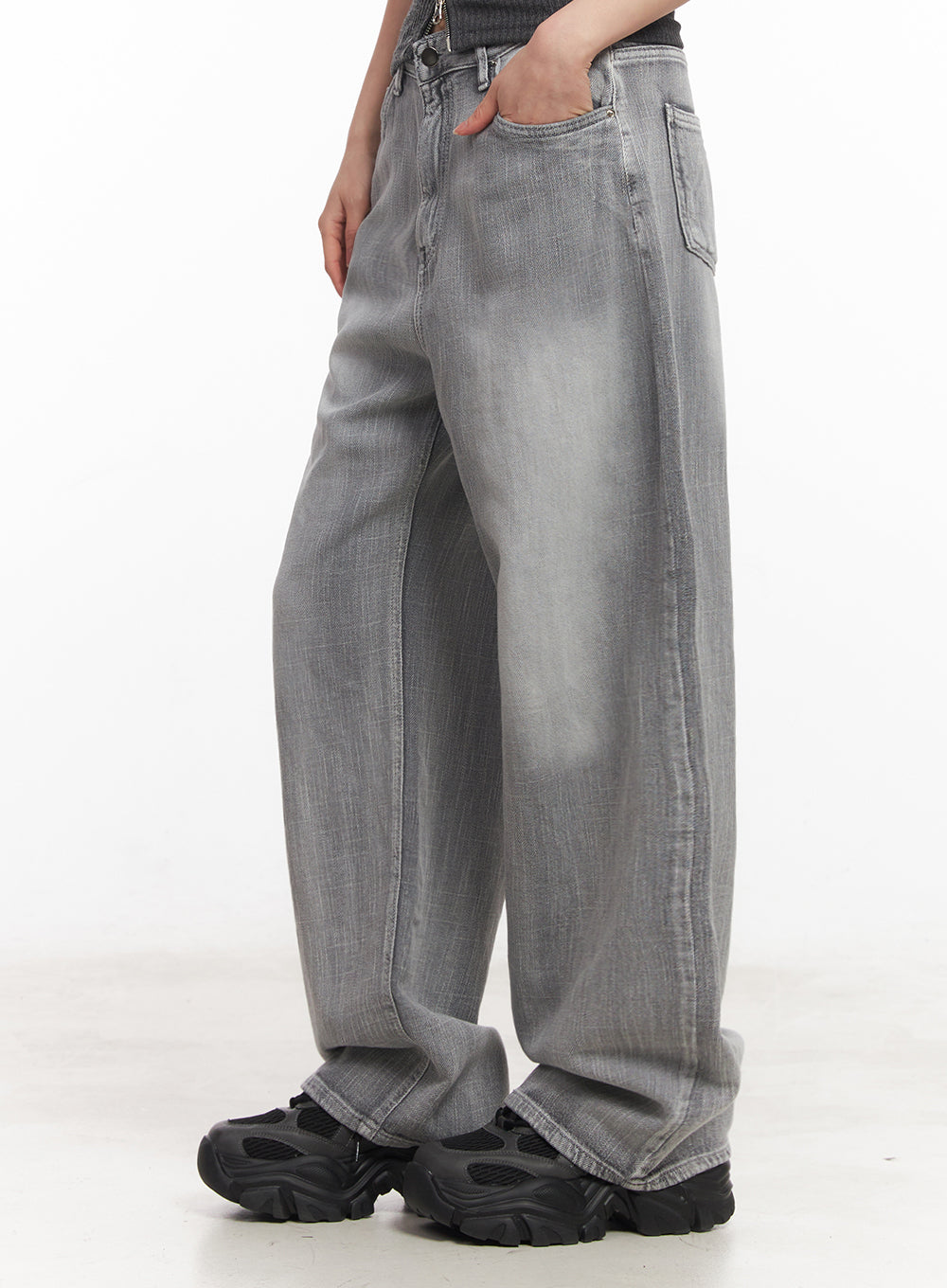 Flore Washed Wide-Leg Jeans IY516 in gray, side close-up waist-to-hem on model, washed cotton denim with voluminous leg and subtle crease texture, chunky sneakers.