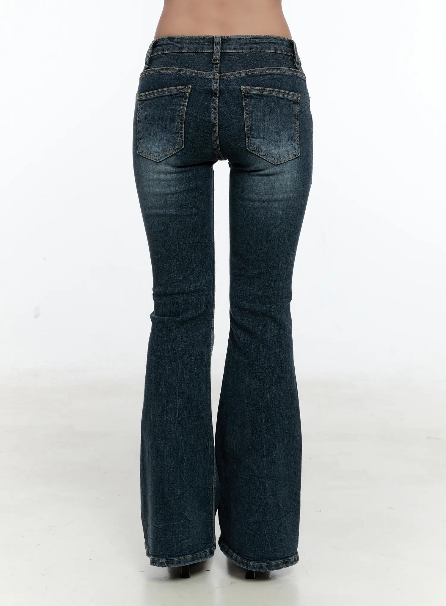 Harlee Bootcut Jeans CS517 in dark blue, back close-up from waist to hem on model, featuring two back patch pockets, washed fading, and wide bootcut flare at the hem.