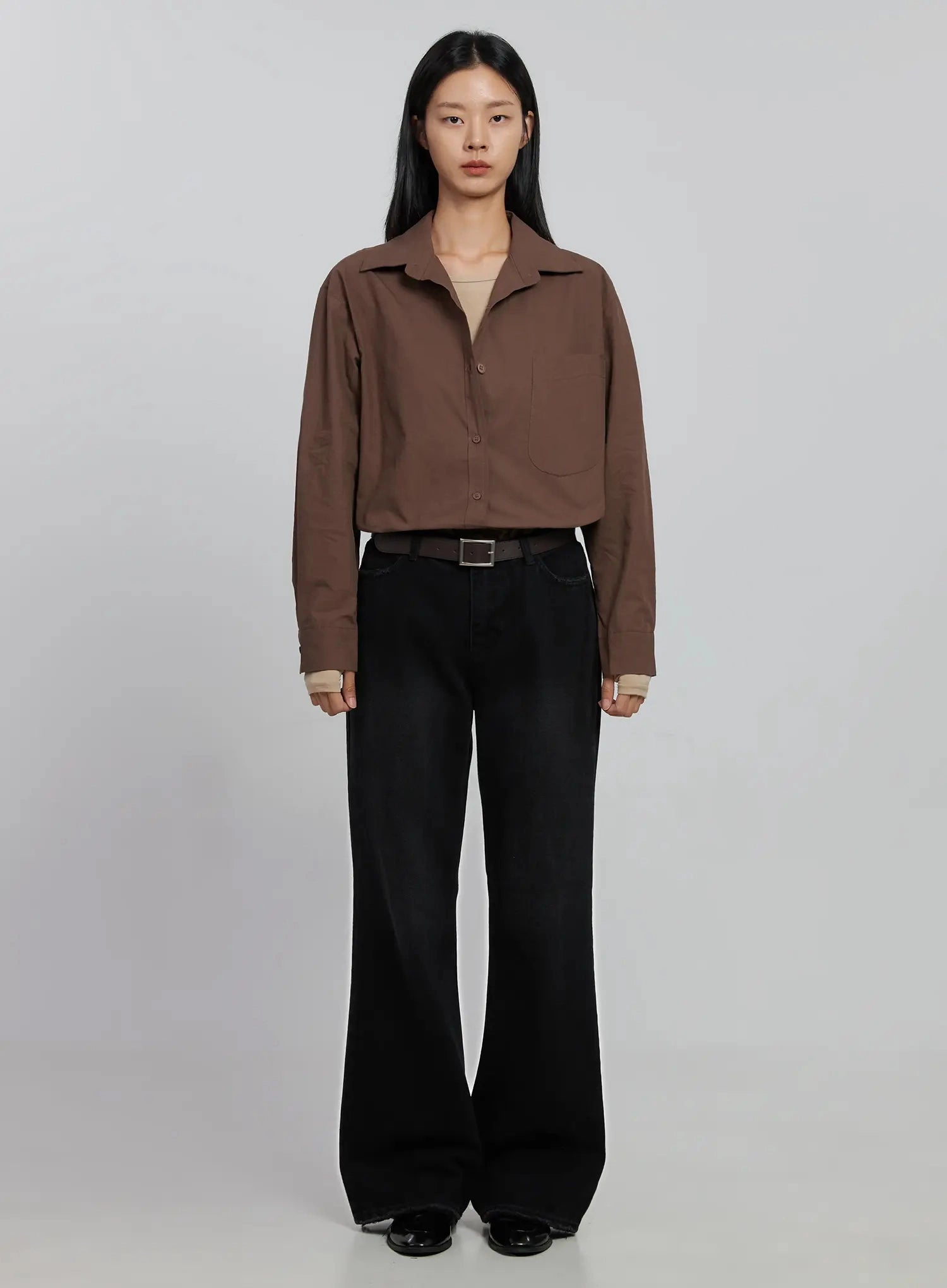Imani Wide-Leg Flared Jeans ID516 in black, full-body front on model, styled with cropped brown shirt, beige layered top and dark belt, long wide-leg flare pooling at floor, black loafers.