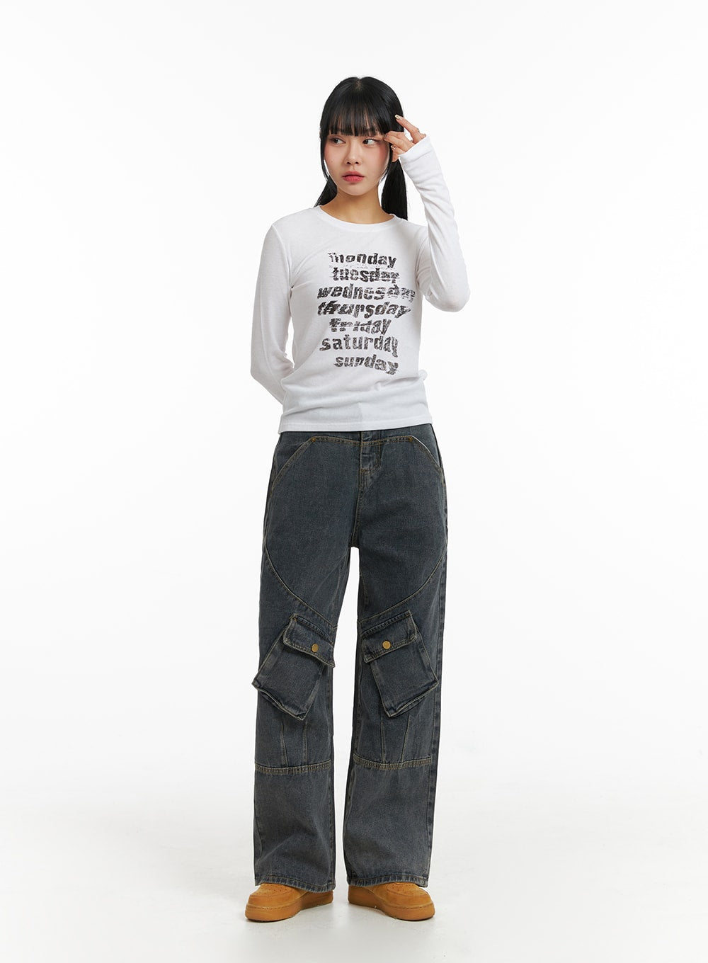 Mid Waist Cargo Jeans CJ411 in dark blue, front full-body view on model with hand raised, wide-leg washed denim cargo jeans with snap pockets and curved knee seam detailing.