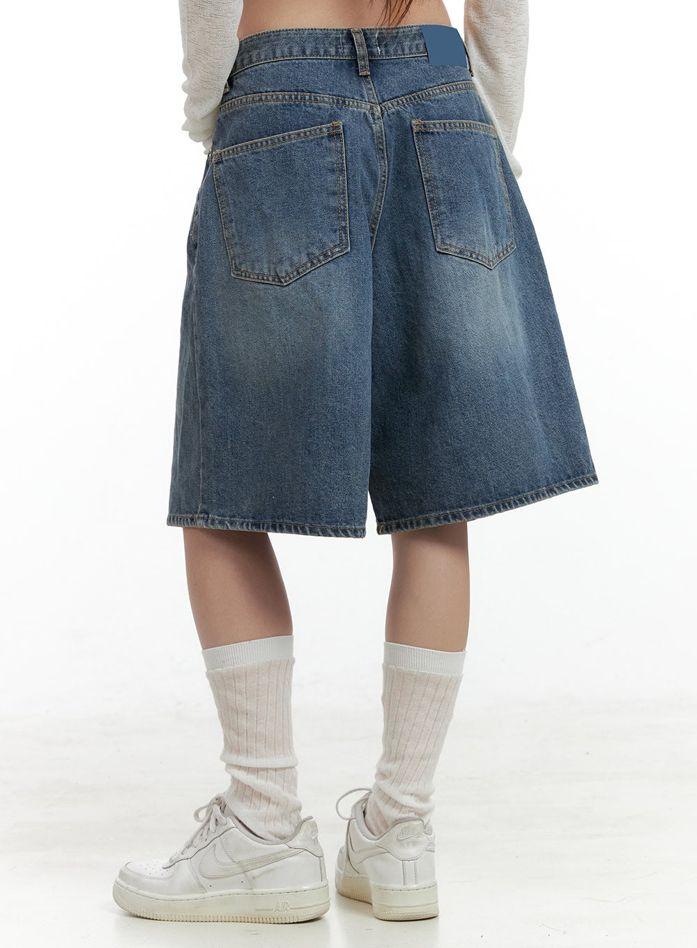 Low Rise Bermuda Jorts CL424 in blue, back close-up from waist to hem, washed denim with dual back pockets and faded tone, wide-leg cut, worn with white socks and sneakers.