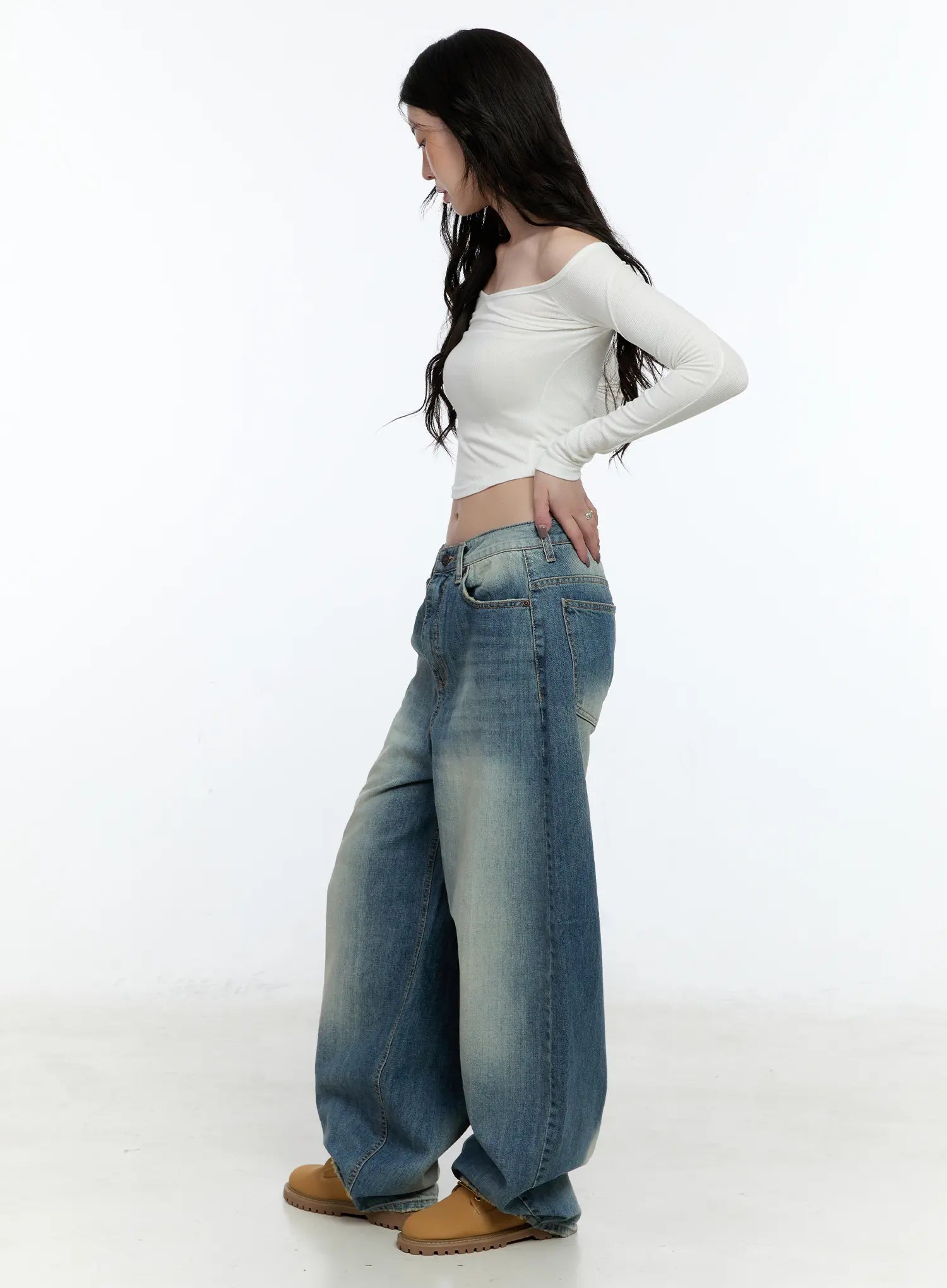 Jiso Baggy Wide Jeans CN517 in blue, side full-body shot on female model, washed cotton balloon wide leg with low waist rise visible, styled with white off-shoulder crop top.