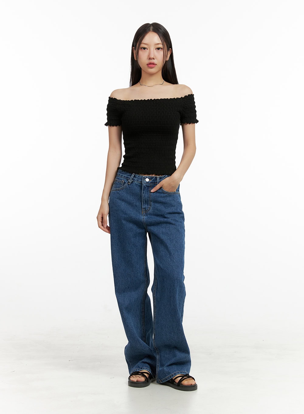 Blue Wide-Leg Jeans OU407 in blue, straight-on front full-body shot on model hand-in-pocket pose, wide-fit washed denim with high waist and relaxed wide leg, paired with black off-shoulder top.