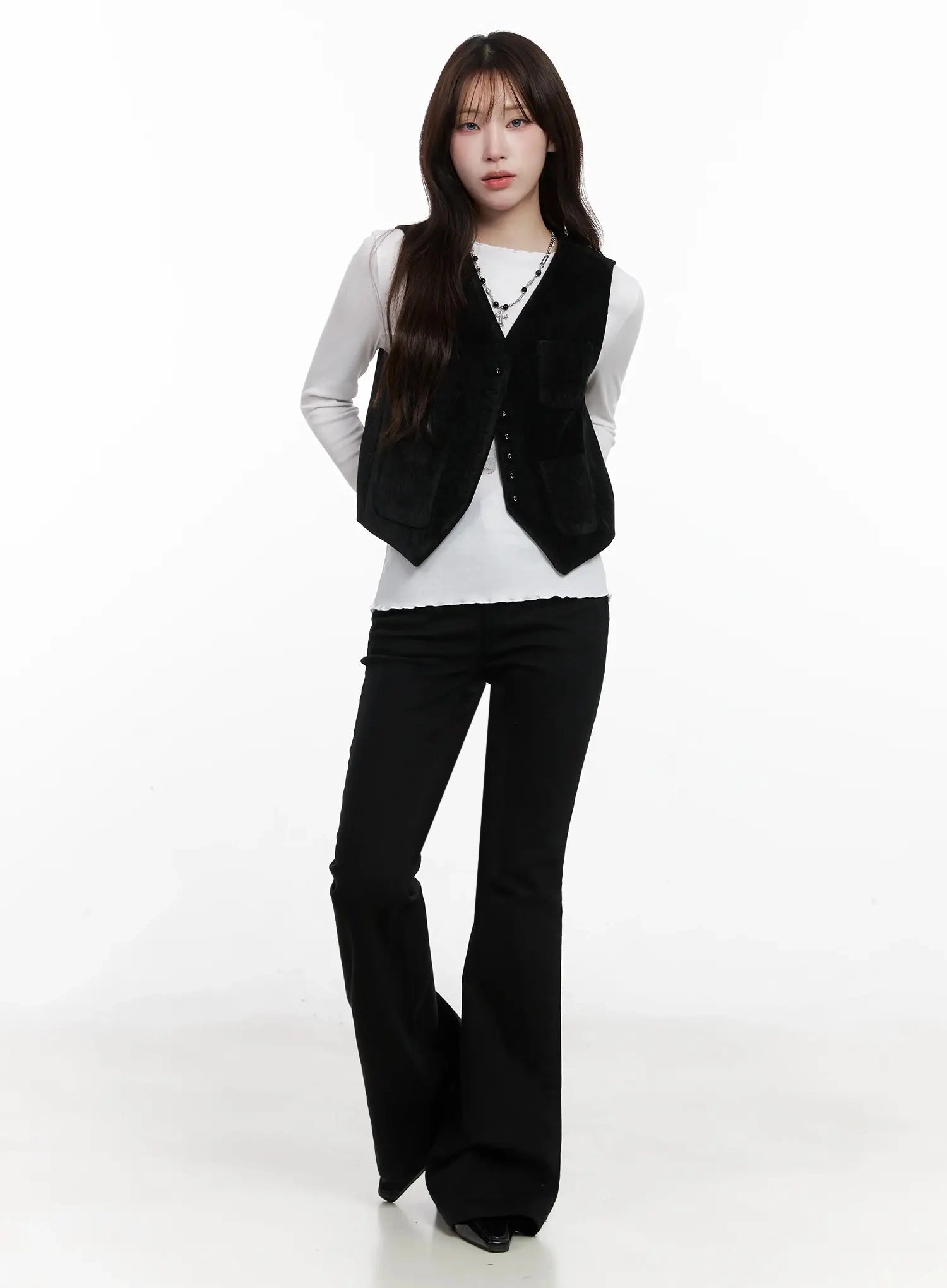 Dream Chic Black Flare Jeans IN514 in black, full-length front on model, layered with black suede vest and white long-sleeve top, necklace accent, floor-grazing flare hem.