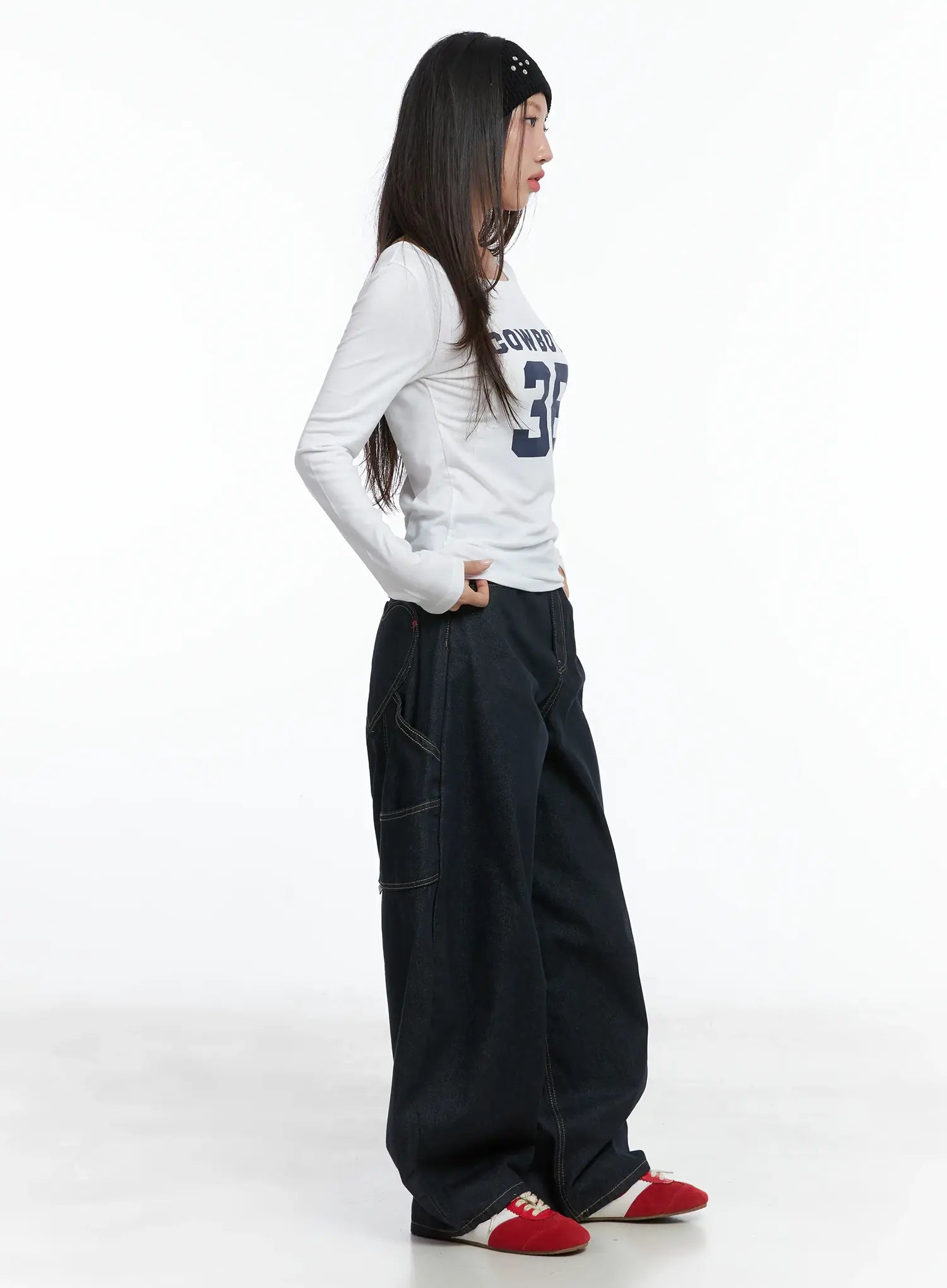 Heart Pocket Balloon Jeans CS503 in dark indigo, full side view on model, oversized balloon fit with dropped crotch, side cargo pocket, paired with white long-sleeve top and red sneakers.
