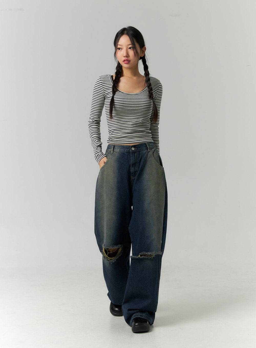 Destroyed Washed Wide Leg Jeans CN324 in dark blue, full-length front walking pose on model, wide-leg hem dragging on floor, dual torn knee openings visible, styled with fitted striped long-sleeve top.