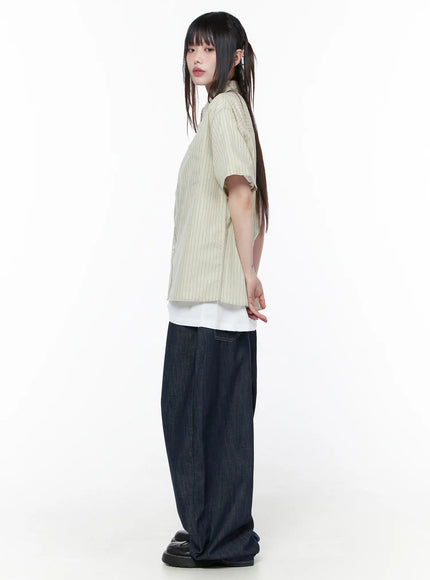 Rowen Baggy Jeans CU519 in dark blue, side full-body on model, showing wide-leg balloon volume from hip to hem, paired with striped shirt and white underlayer, black platform loafers.