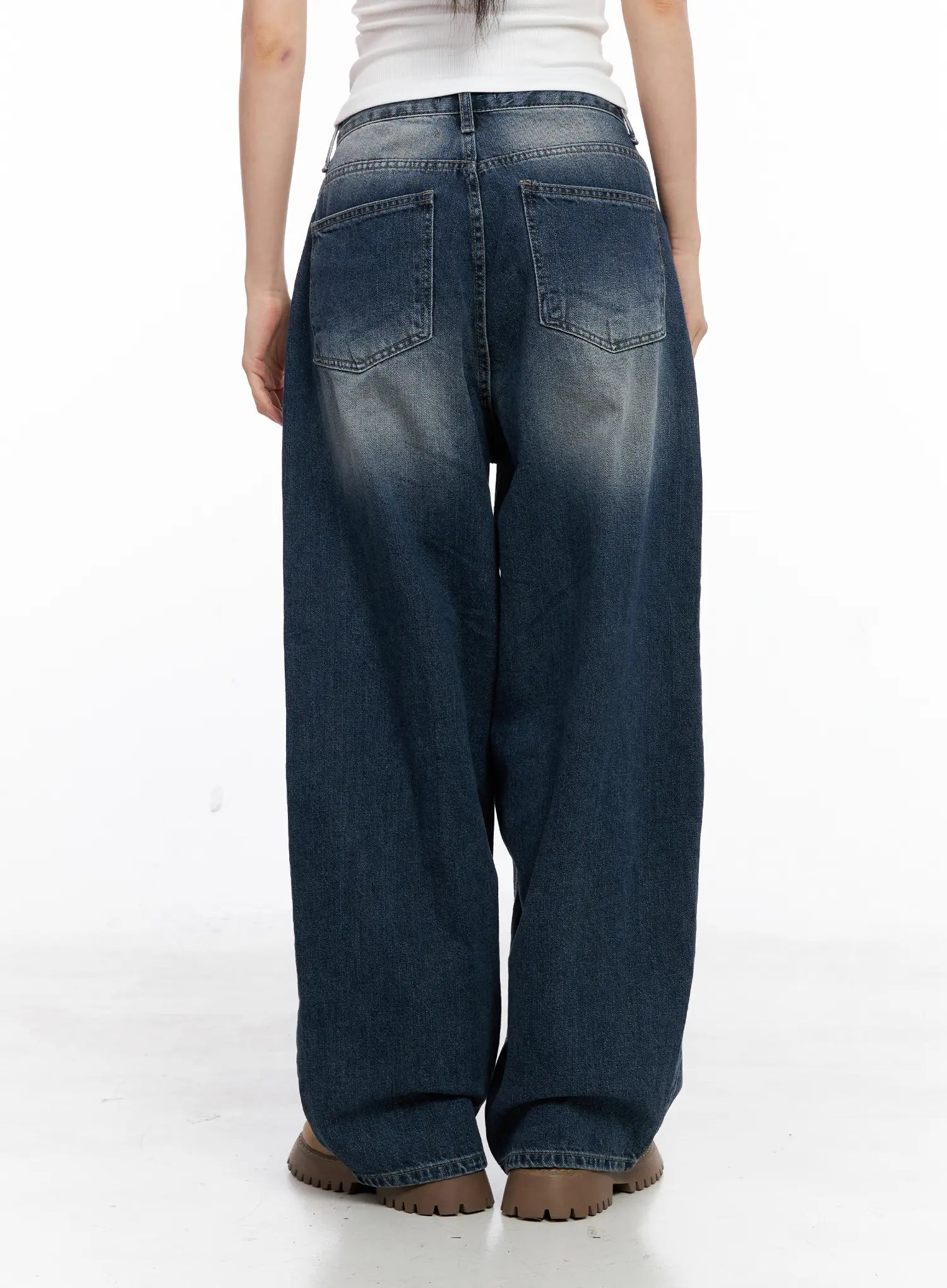 Aisha Washed Baggy Jeans CC1109 in mid blue, back view on model, showing back patch pockets, washed fading detail, and roomy baggy silhouette in long-length cotton denim.