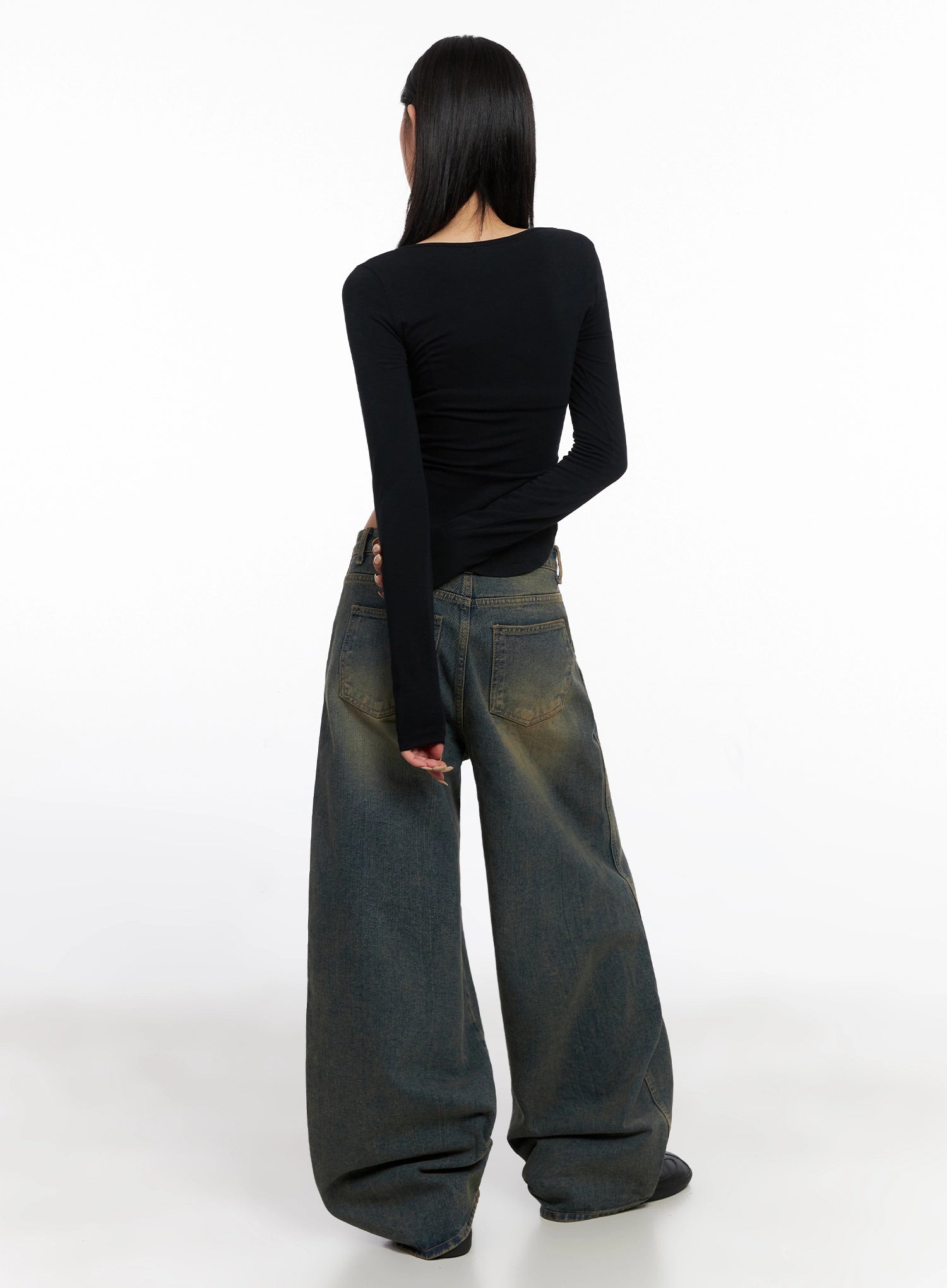 Minju Vintage Washed Baggy Jeans IS508 in dark blue, back full-length on model, revealing back pockets and voluminous wide leg hem puddle, worn with black long sleeve top and black shoes.