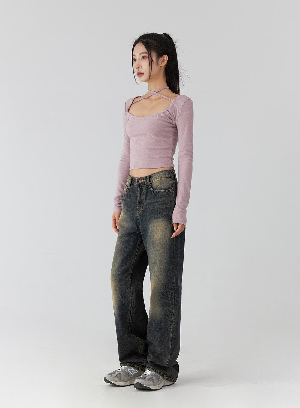 Wide Leg Jeans CD322 in dark blue, three-quarter side view on model, washed cotton denim with vintage amber fading, wide straight leg, regular length, paired with pink halter crop top and New Balance sneakers.