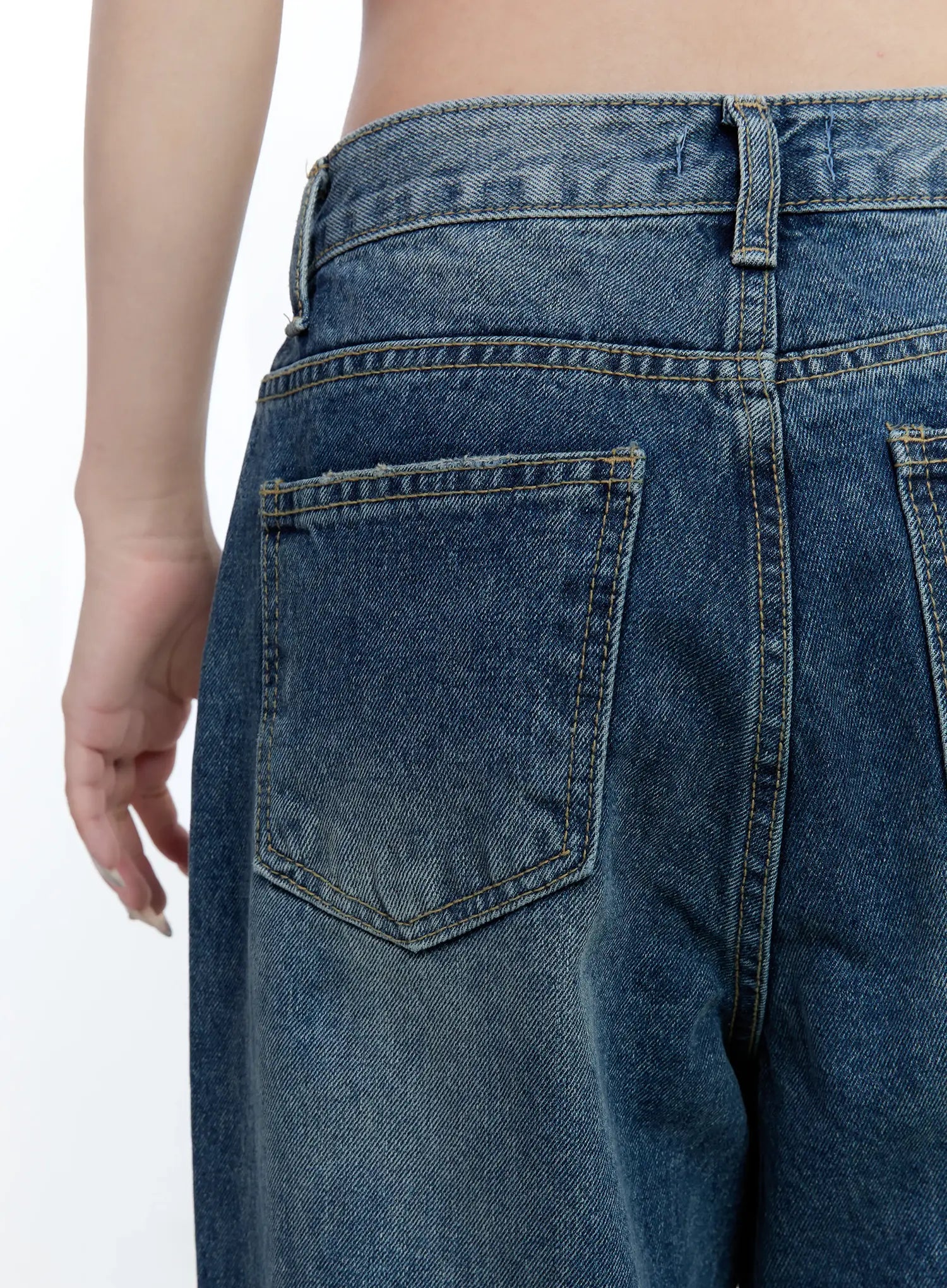 Gabi Distressed Semi-Flared Denim Jeans CG501 in dark blue, back waistband close-up on model, highlighting washed cotton texture, back pocket stitching, and belt loop detail.