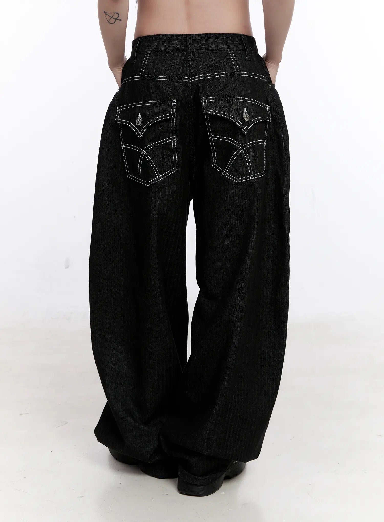 Vada Stitched Wide Leg Jeans CS530 in Black, back close-up on model, bold contrast white stitching on curved back pockets with teardrop hardware detail, balloon wide-leg cotton denim.