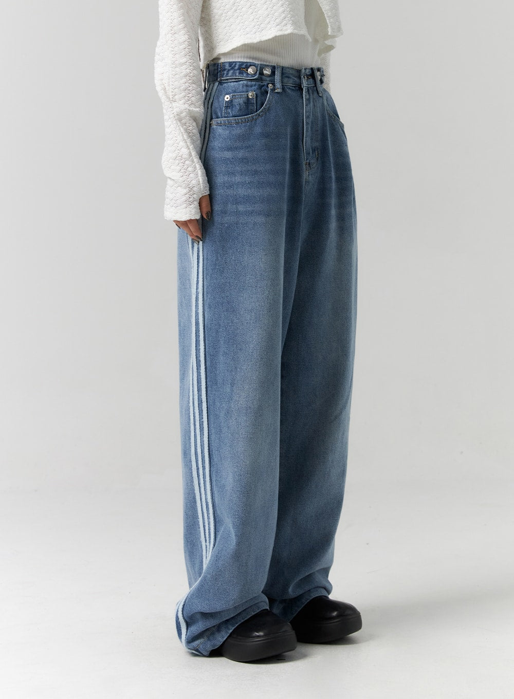 Side Stripes Wide Leg Jeans CS314 in blue, side view close-up on model, showcasing dual white side stripes running full length of wide-leg washed denim, high-rise fit.