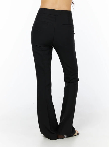 Basic High-Waist Stretch Flared Slacks CU522 in black, back close-up on model, rear welt pocket detail, high-rise waistband, flared leg silhouette visible from waist to heel.