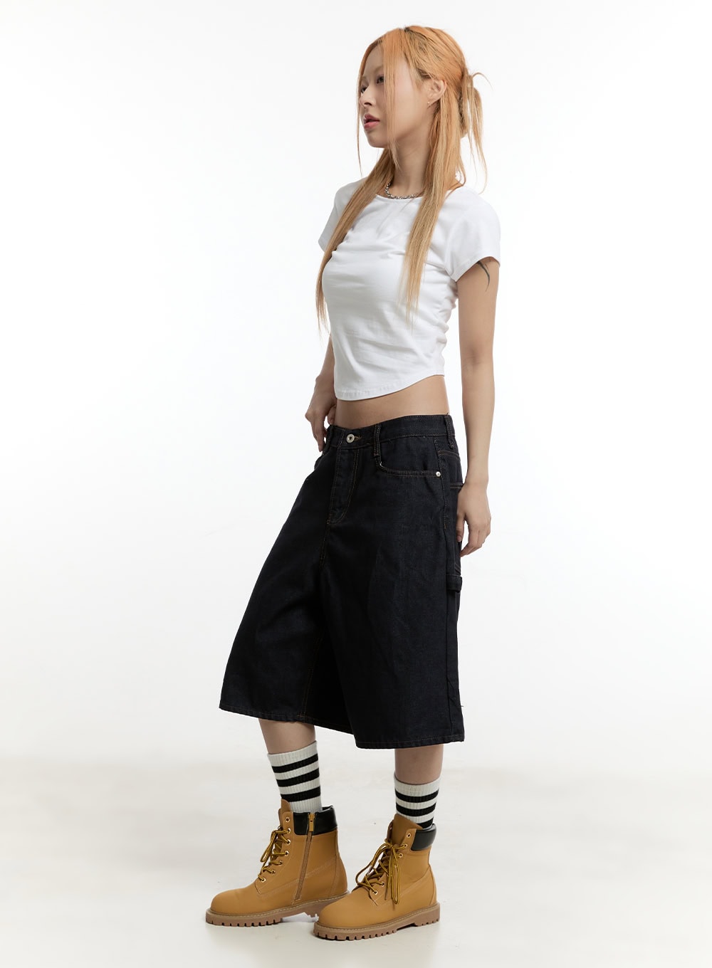 Carpenter Denim Wide-Leg Jorts CY501 in dark blue, full-body side shot on model, low-rise wide-leg midi jorts showing side silhouette, styled with white crop tee and tan lace-up boots.