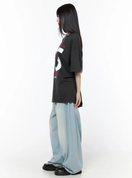 Ozzy Washed Wide Leg Jeans CU519 in light blue, side profile full-length shot, model in graphic tee, wide-leg silhouette with gradient bleach wash visible.