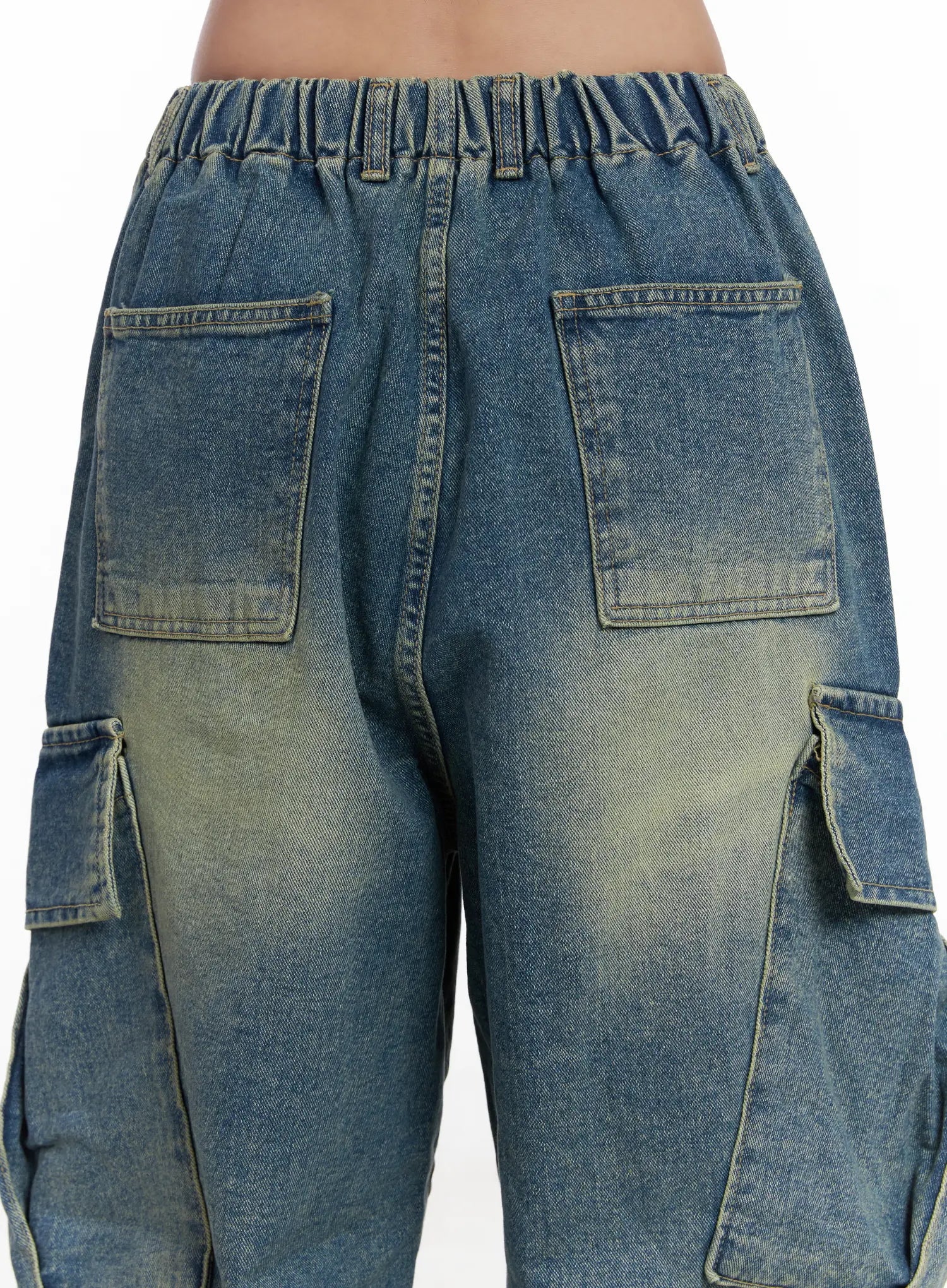 Jake Wide-Leg Cargo Jeans CJ515 in blue, back waist close-up on model, revealing elasticated waistband, dual back patch pockets, and washed yellow-tinted denim fade detail.