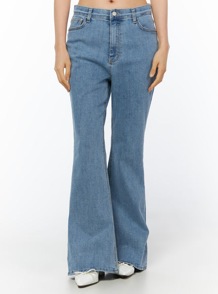 Leana Stretch Bootcut Jeans IU519 in blue, front view on model hands at sides, long bootcut leg with center seam, 5-pocket style, washed cotton-spandex, white ballet flats.