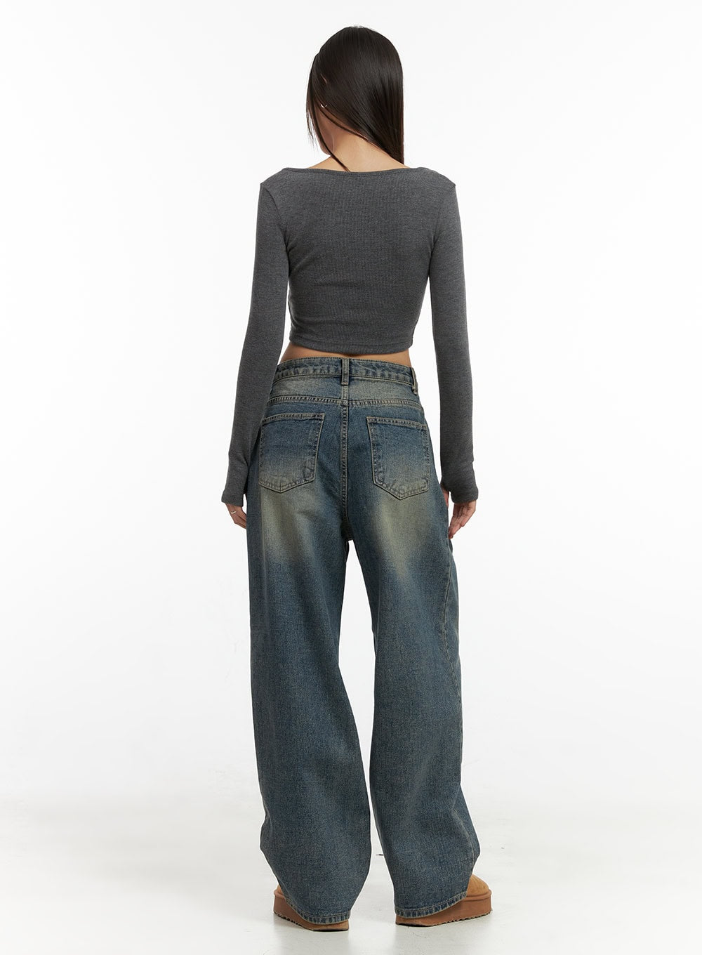 Peyton Pin-Tuck Washed Baggy Jeans CO424 in blue, full-body back shot on model, back pocket detailing and relaxed wide fit visible, paired with grey ribbed crop top and tan boots.
