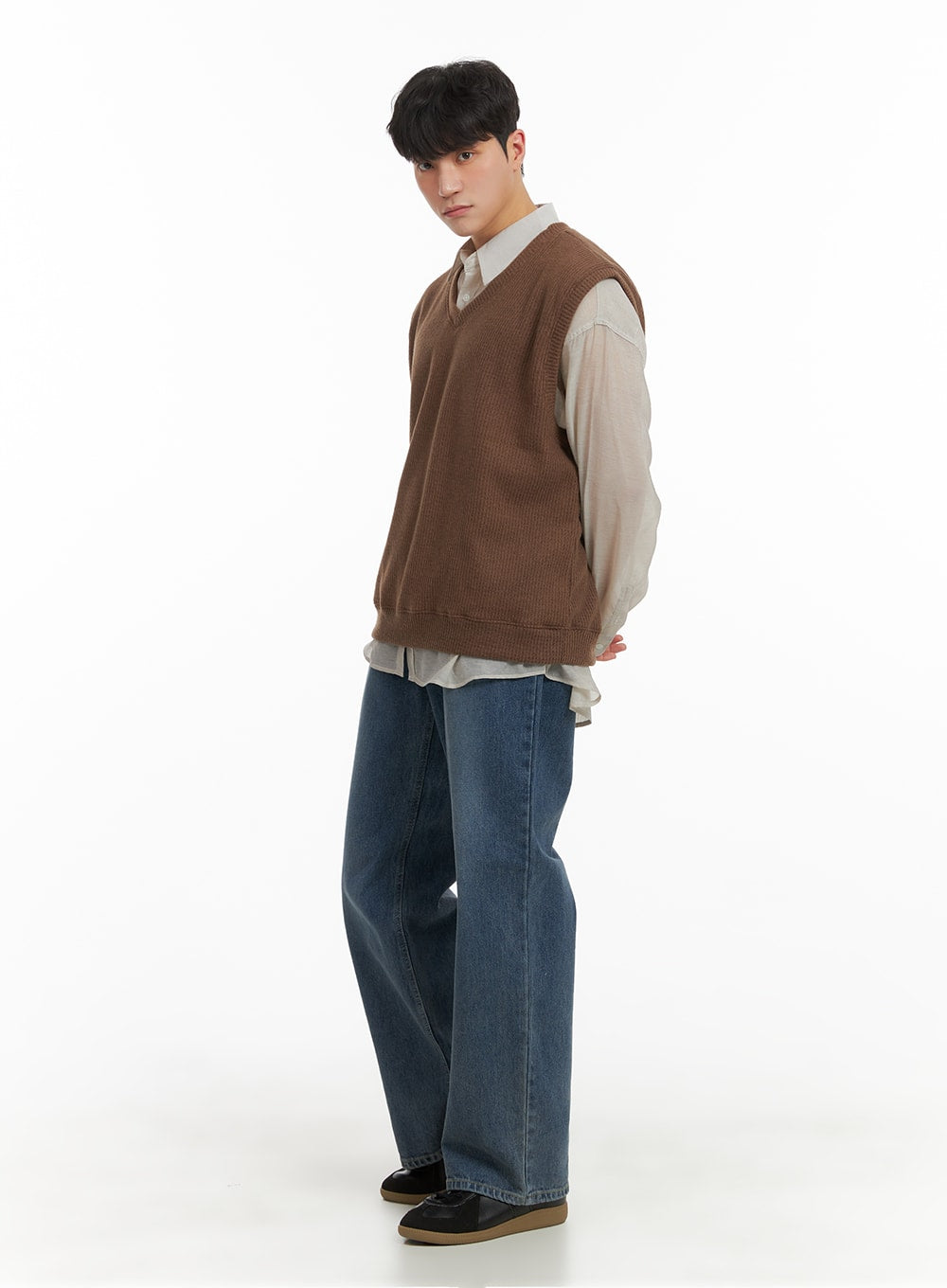 Men's Washed Denim Wide Fit Jeans IA402 in blue, 3/4 side view on model, relaxed wide fit, layered with beige shirt and brown knit vest, black loafers completing the look.