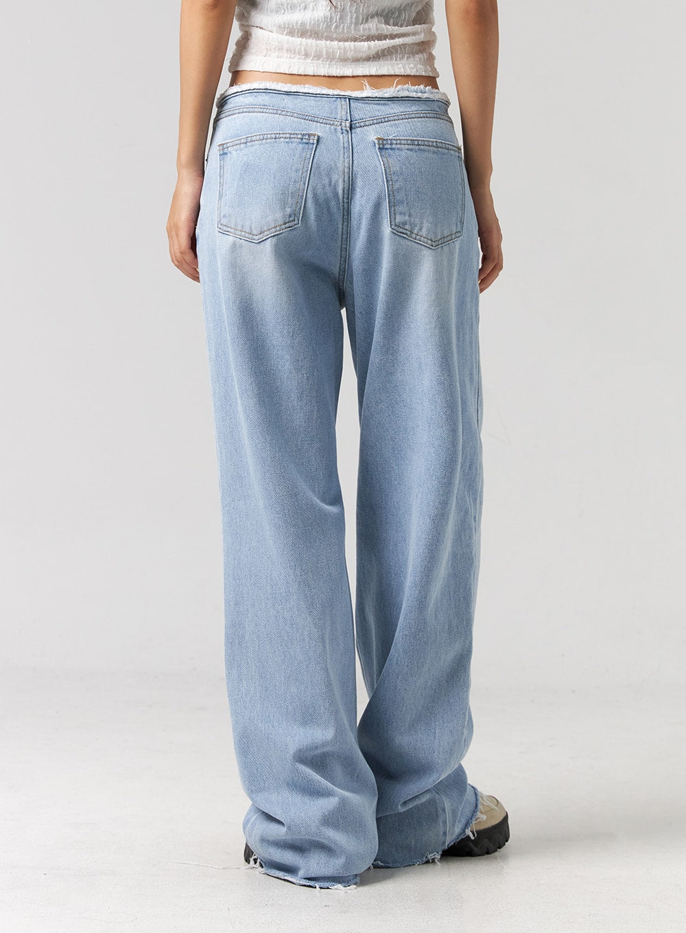 Cut Waist Wide Leg Jeans CG323 in light blue, back full-length shot on model, two back pockets, frayed cut waistband detail, wide relaxed leg with raw hem at ankle.
