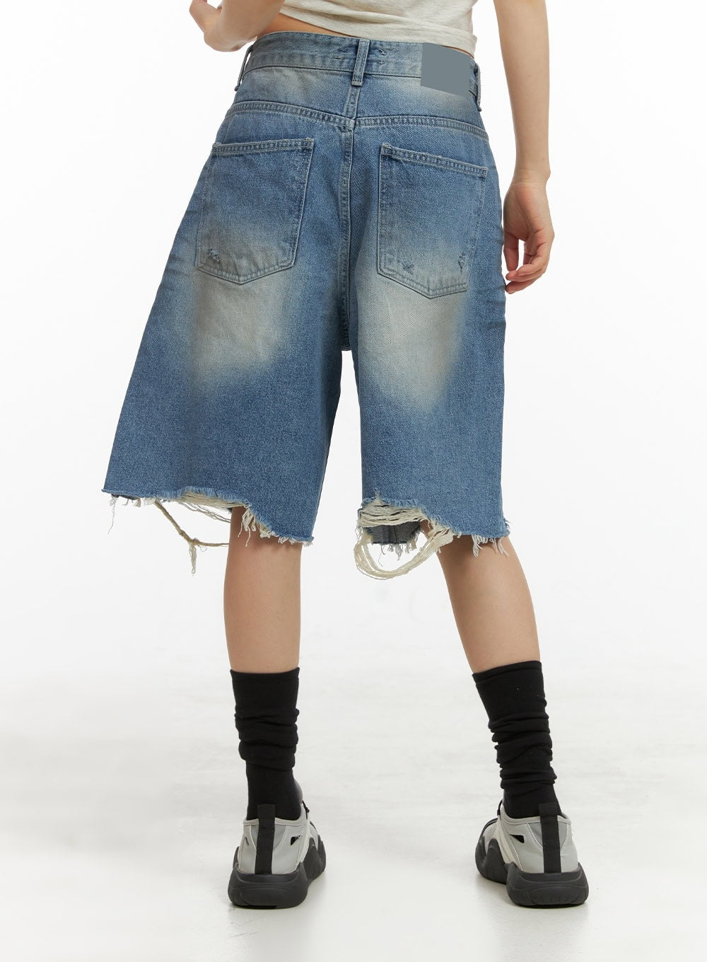 Destroyed Hem Bermuda Jorts CY414 in blue, back close-up on model, wide-fit washed denim showing back pockets, faded seat detailing, and heavily frayed destroyed hem with dangling threads.
