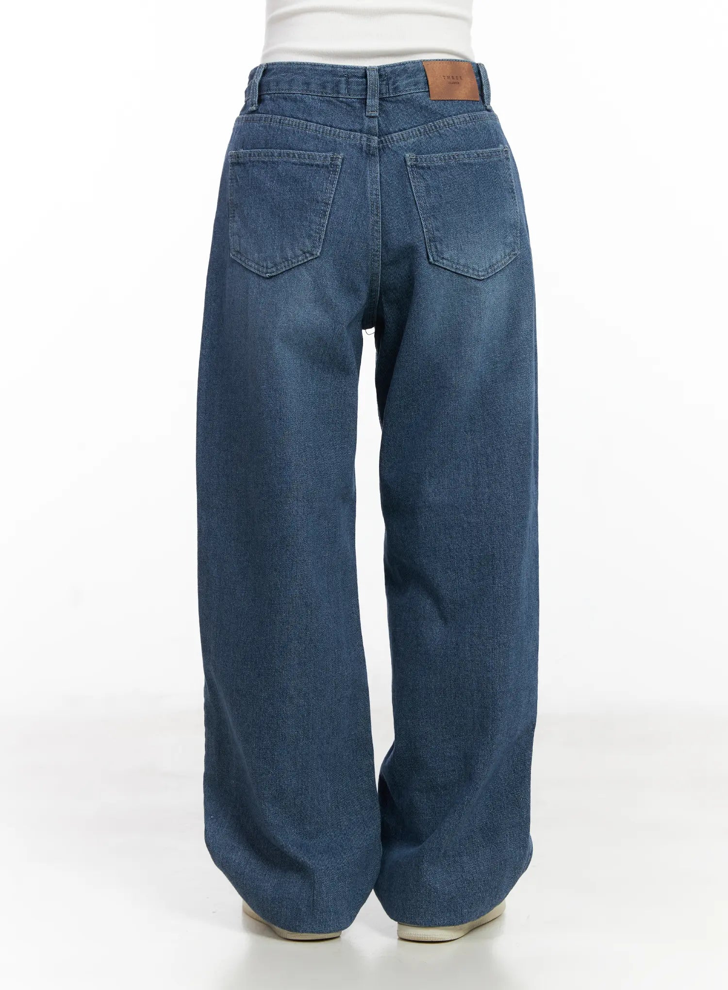 Mariam Baggy Jeans CN526 in blue, full back view on model, washed cotton wide-leg denim with two back pockets and leather brand patch at waistband.