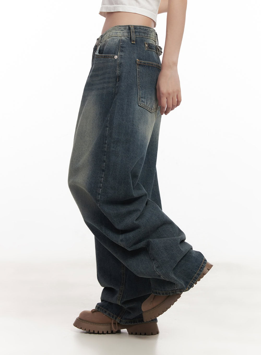 Leilani Washed Baggy Jeans CM531 in dark blue, side close-up on model, wide-fit washed cotton denim with visible back pocket and heavy hem stacking, worn with white crop top.