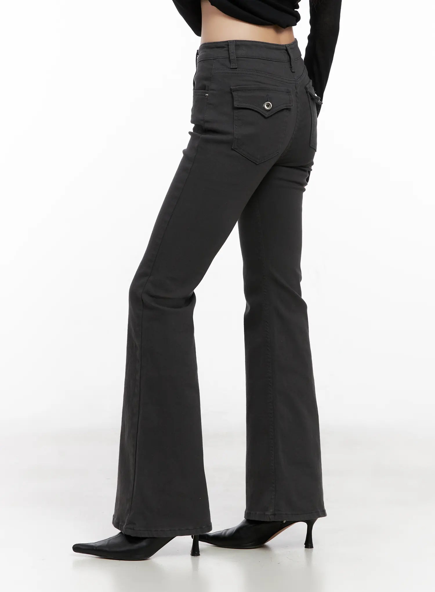Addie Chic Flared Jeans CG522 in dark gray, three-quarter back angle on model, flap back pockets with snap detail visible, flared hem, slim fit, styled with black cropped top and heels.