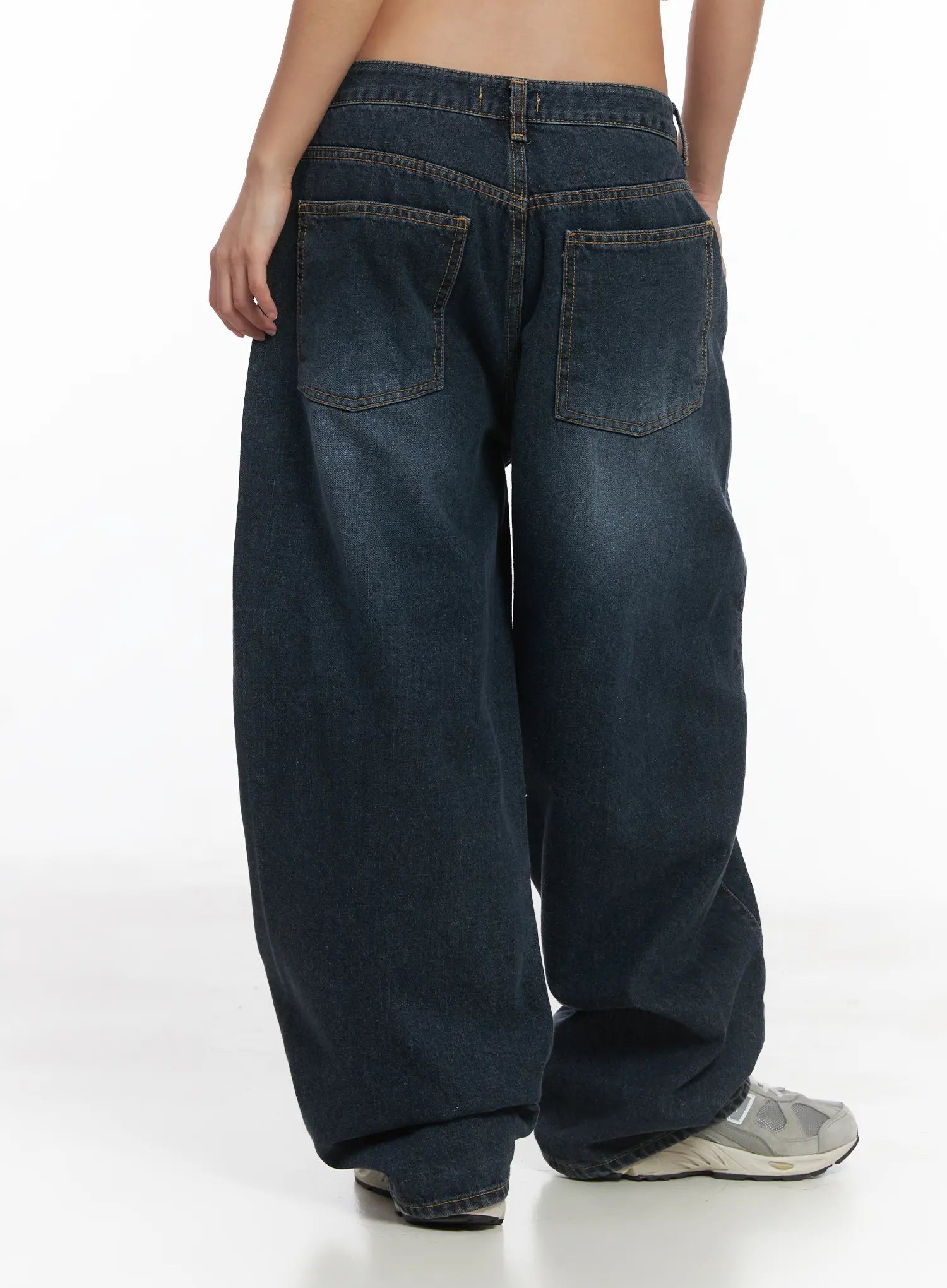 Everly Wide Leg Jeans CJ513 in dark blue, back close-up on model, washed denim with dual back patch pockets and contrast stitching, wide fit with floor-grazing hem and grey sneakers.