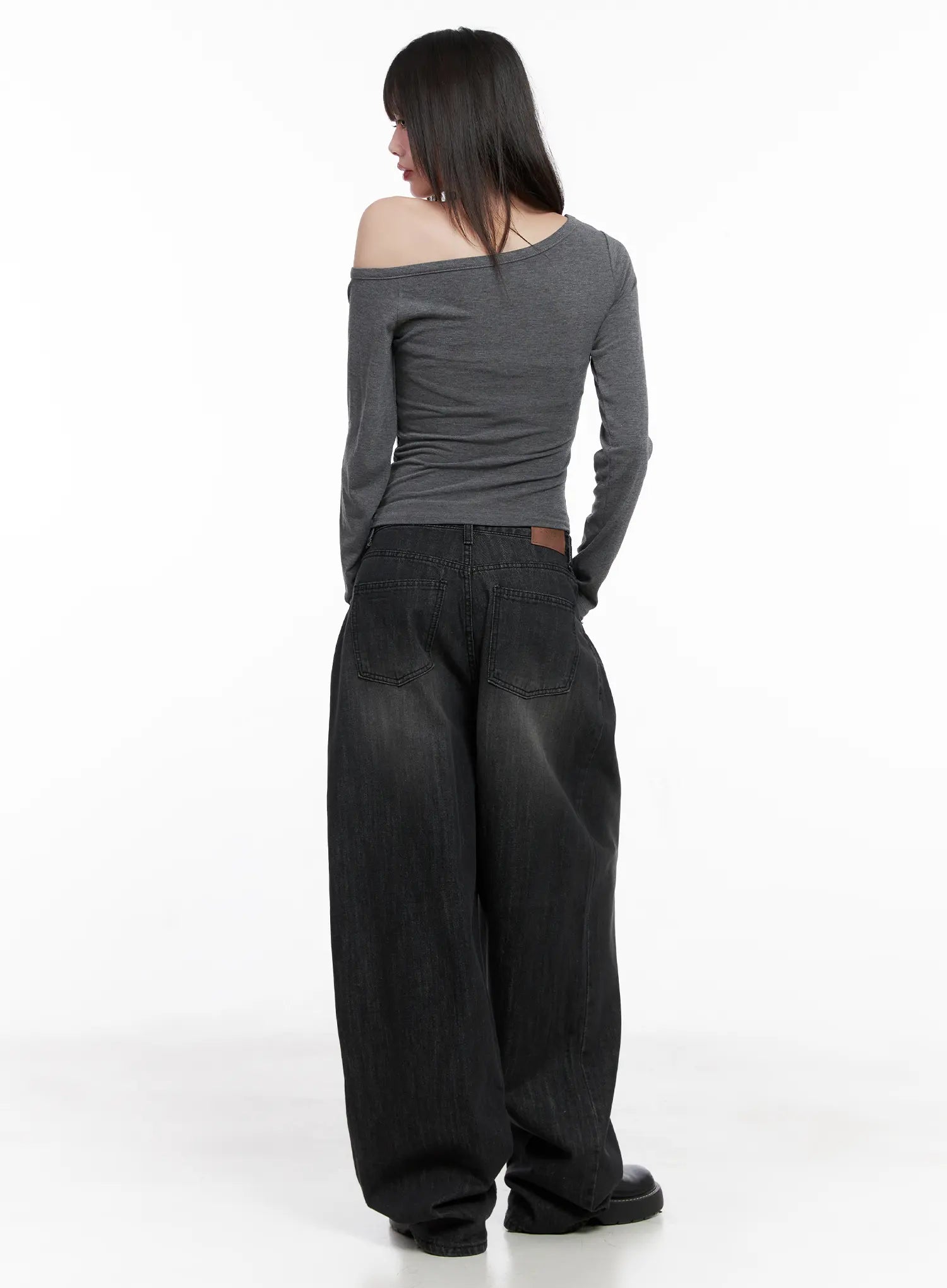 Elen Pintuck Baggy Jeans CG519 in black, back full-length view on model, showing back pockets, brown leather waistband label, and voluminous washed cotton wide leg, with gray top.