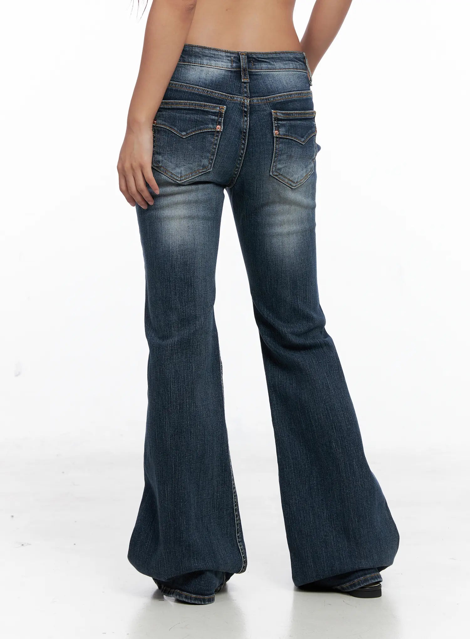 Saanvi Vintage Wash Flare Jeans CS522 in dark blue, back full-length shot on model, dramatic wide flare hem, back pocket stitching and vintage wash visible, long inseam length, no top shown.