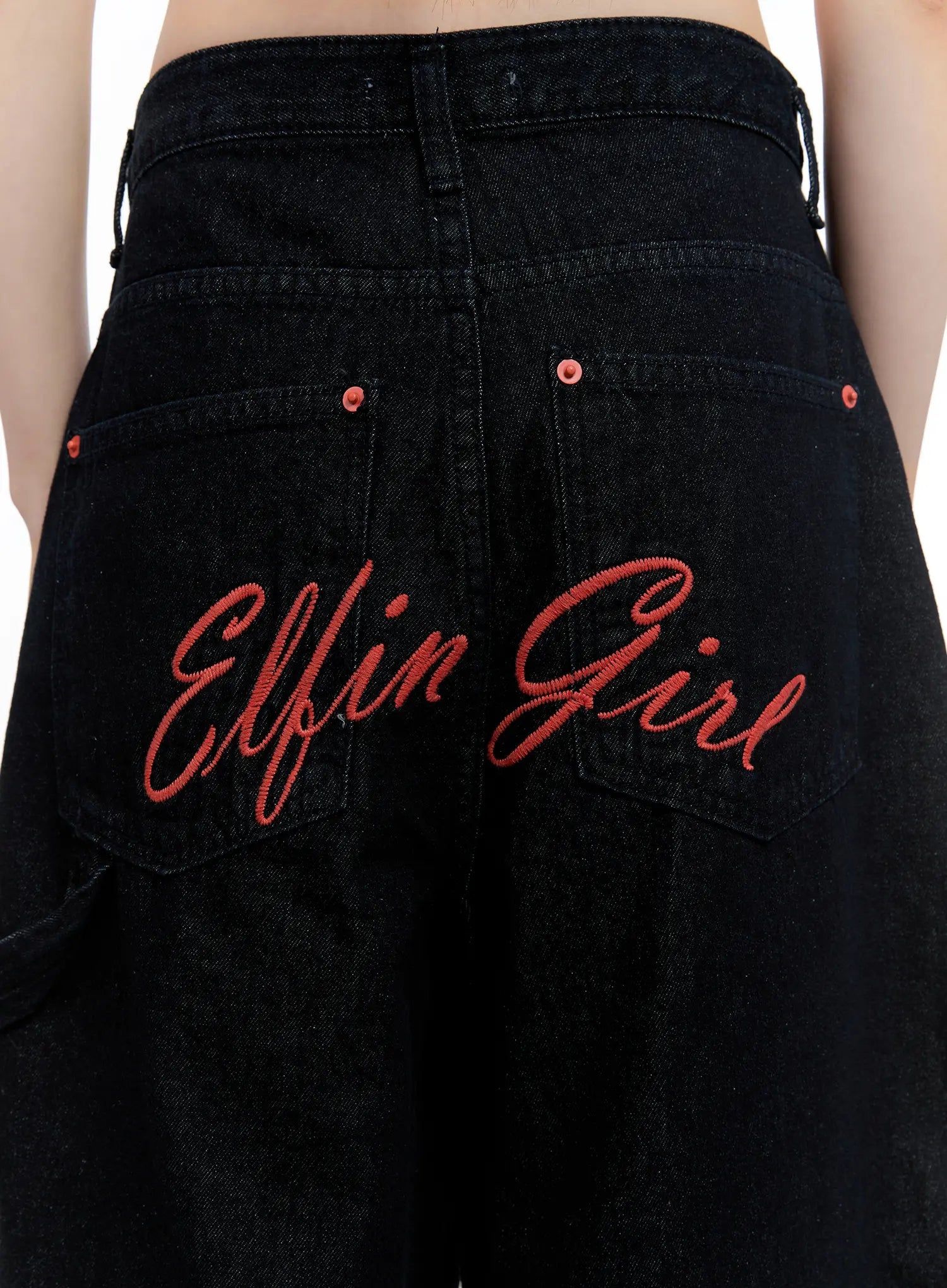 Red Text Graphic Embroidered Jorts CL504 in black, macro back close-up, bold red script 'Elfin Girl' embroidery across back pockets, red rivet details on black denim.
