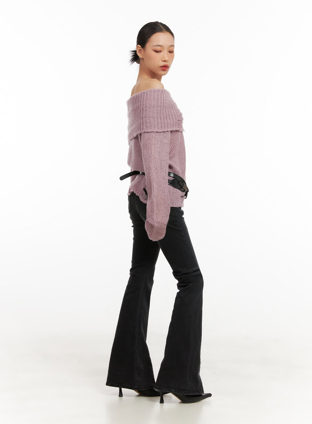 Belle Slim Fit Flared Jeans CD410 in black, three-quarter side view on model, slim fit with flared leg, styled with pink off-shoulder knit and black belt accent.