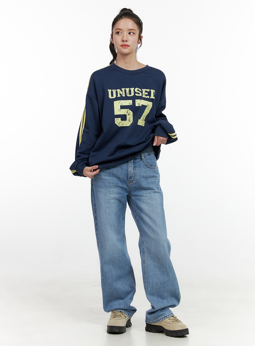 Carly Cloud Wide-Leg Jeans ON404 in blue, full-body front on model standing straight, wide-leg washed cotton denim with clean waistband, styled with navy varsity sweatshirt and sneakers.