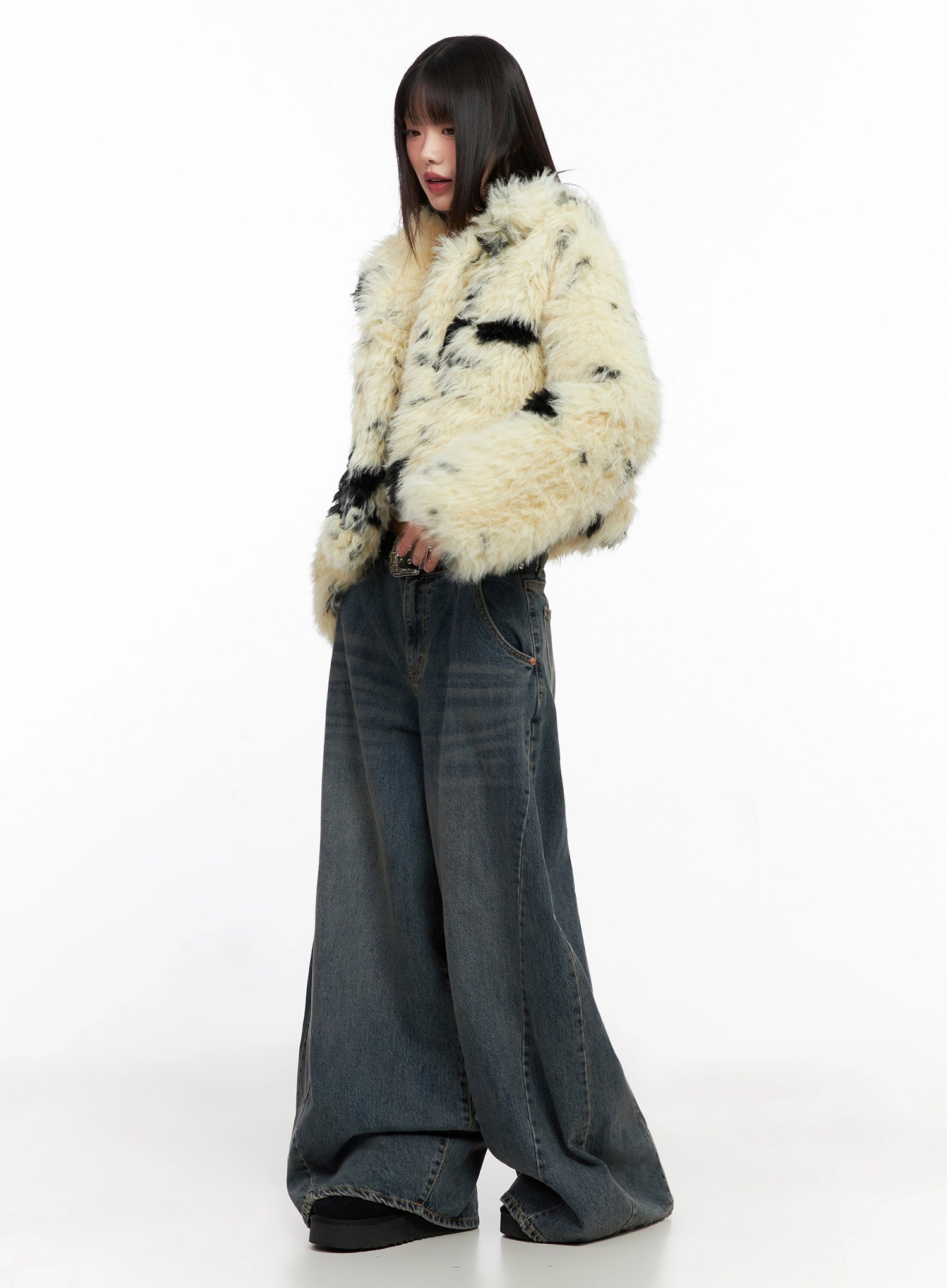 Skyler Washed Balloon Fit Jeans IN503 in blue, three-quarter side shot on model, paired with cream spotted faux-fur jacket, oversized balloon leg falls to floor, casual street look.